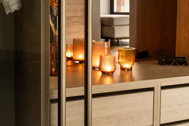 Close-up of a bronze profile and oak interior with lit candles