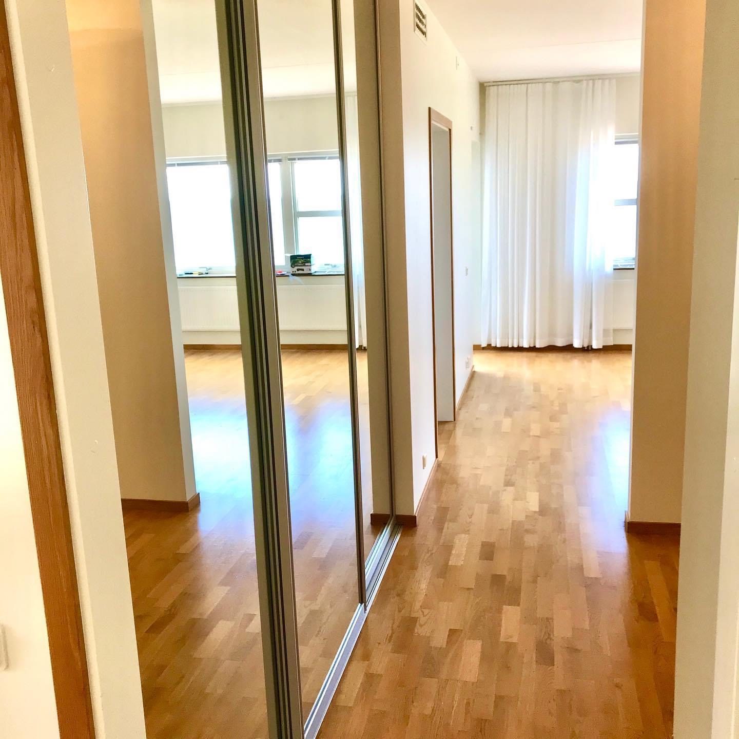 Mirrored doors along a hallway, curtained window