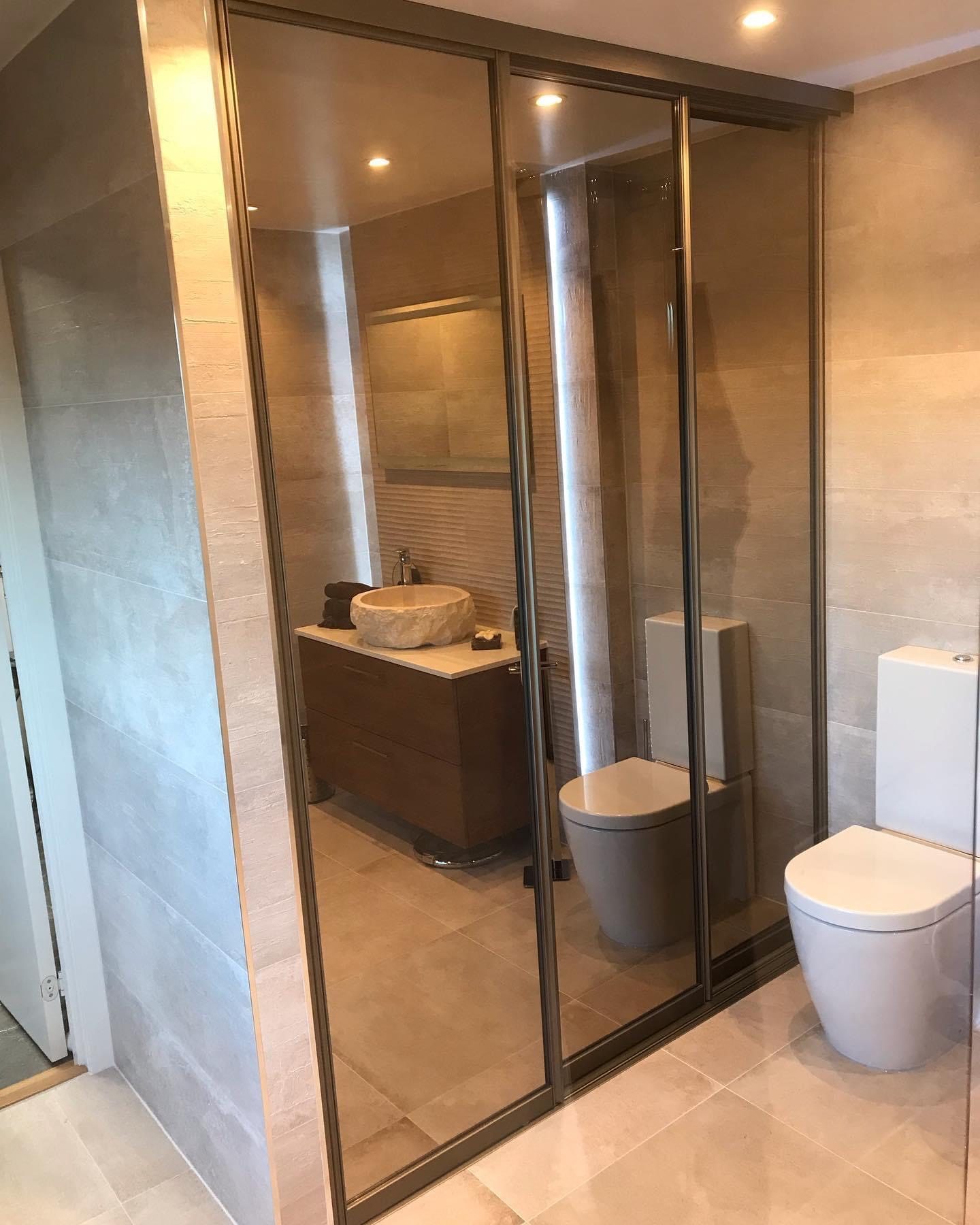 Mirrored doors separate the sink from a bathroom