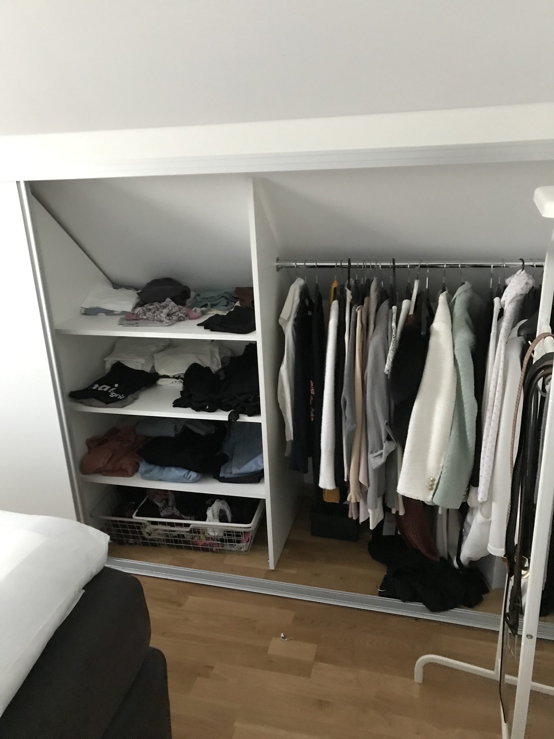 Open shelves and rail under a sloped ceiling