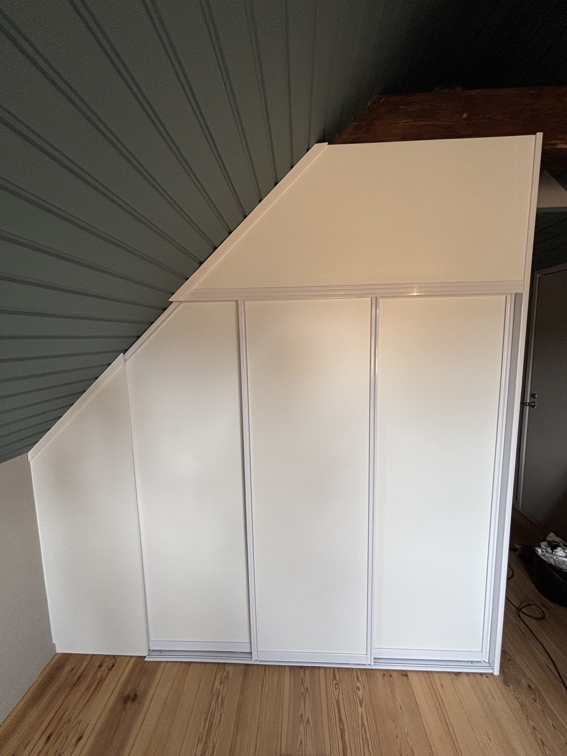 White doors under sloped ceiling, panelled wall
