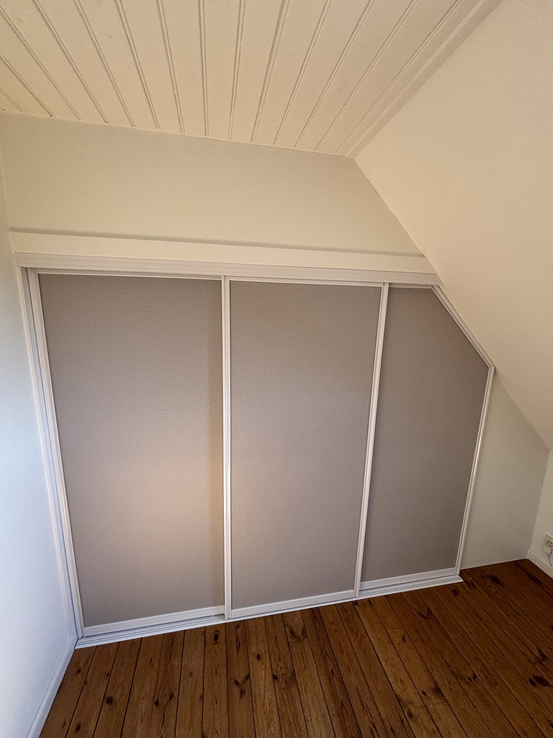 Grey doors in a small attic, wood floor