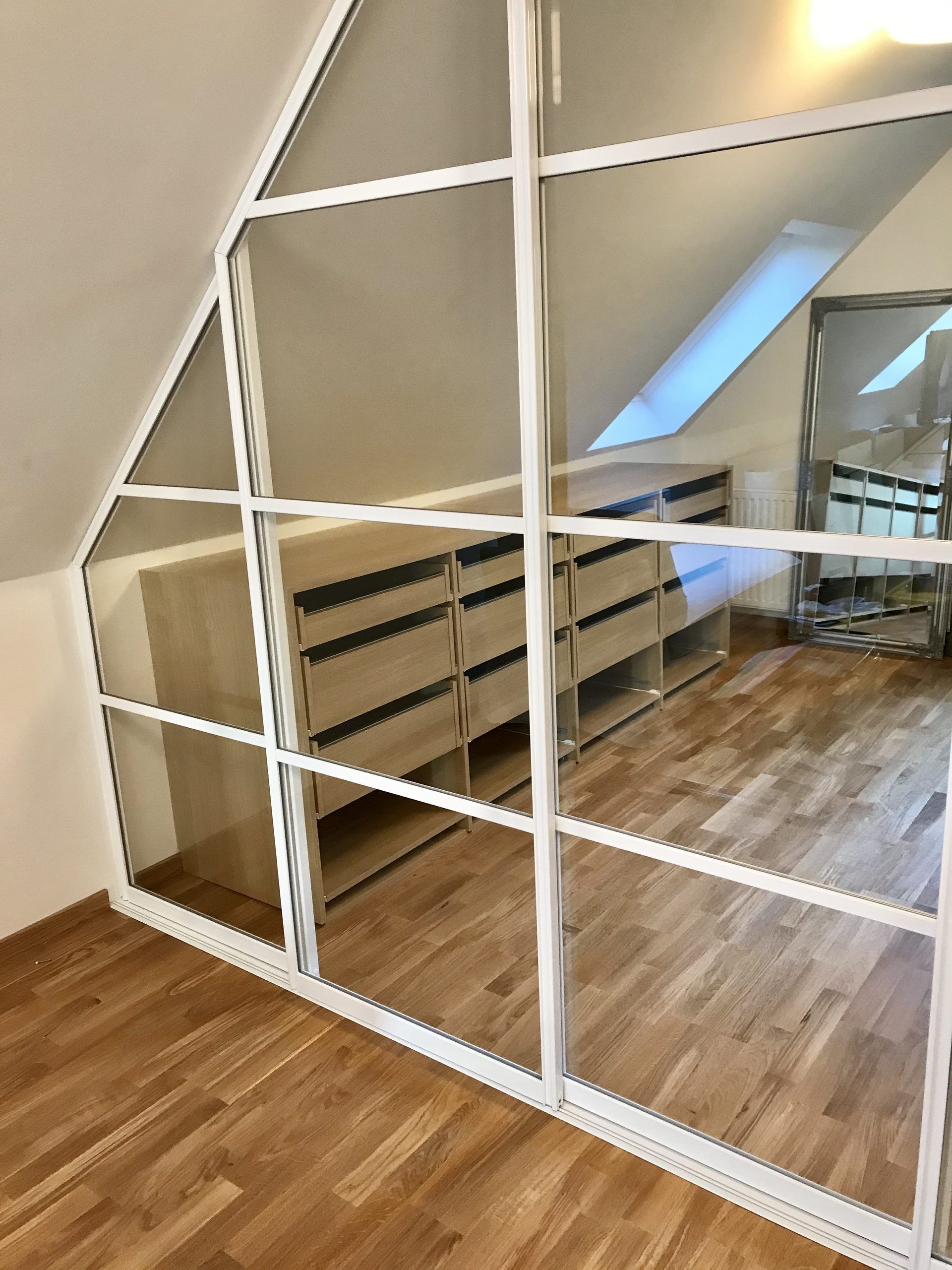 Glass doors under a sloped roof with skylight