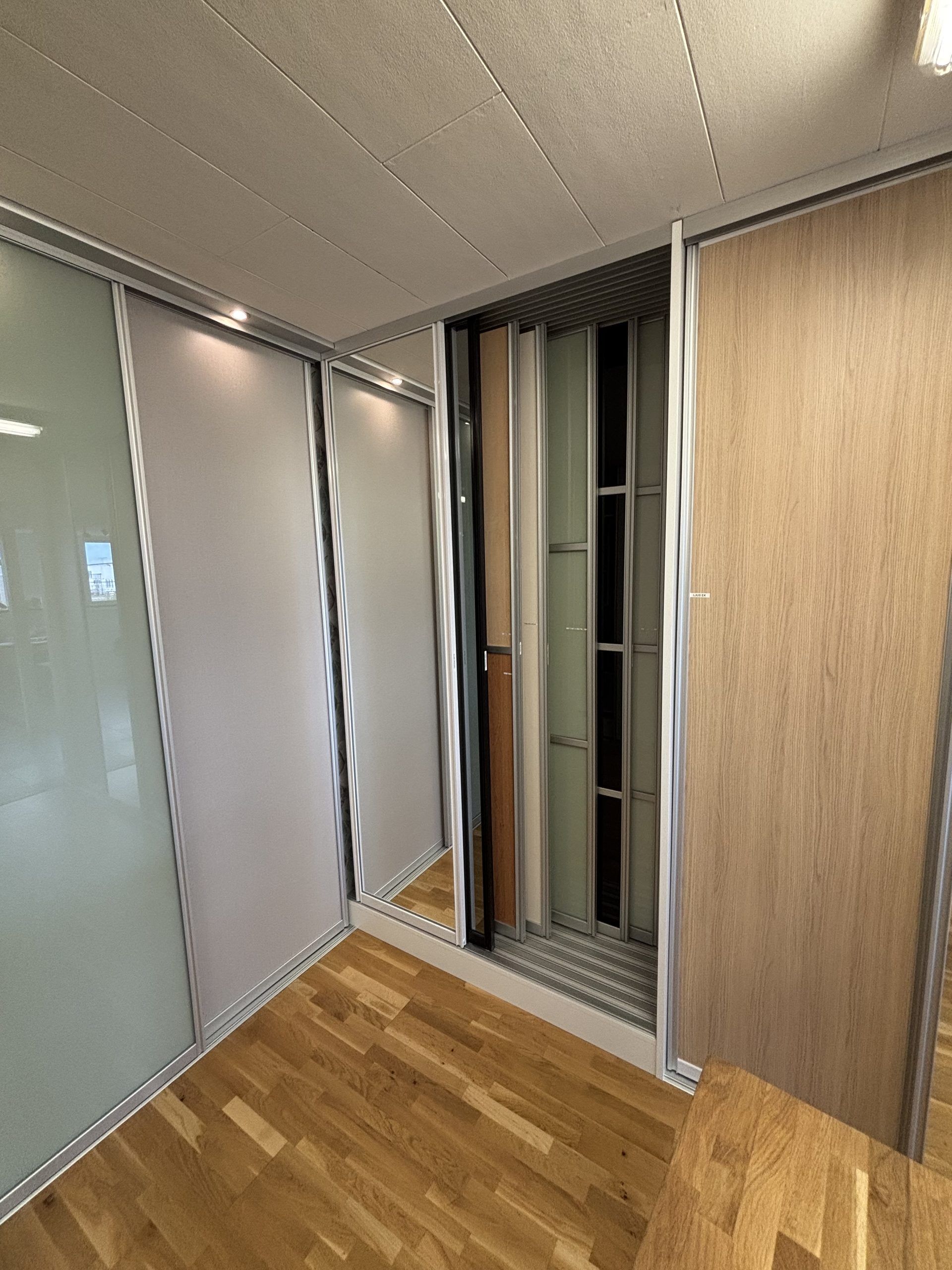 Open sliding door on an oak wardrobe, showroom