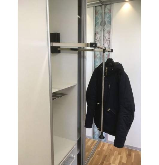 Fold-down clothes rail pulled out at the front of a wardrobe, with a black jacket hanging on it.